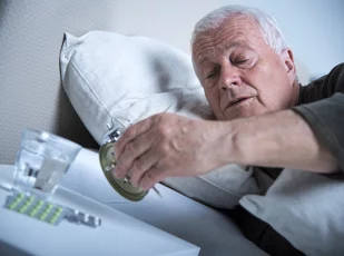 мужчина ставит будильник