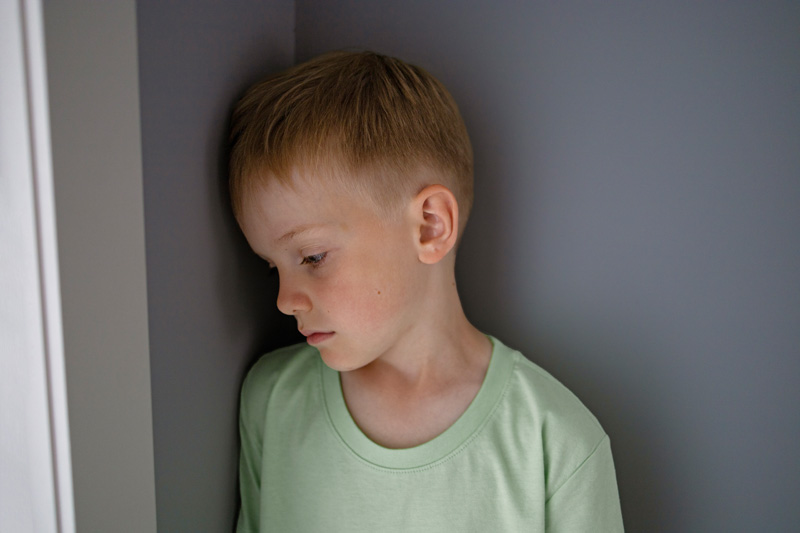 мальчик с тревожным расстройством стоит у стены